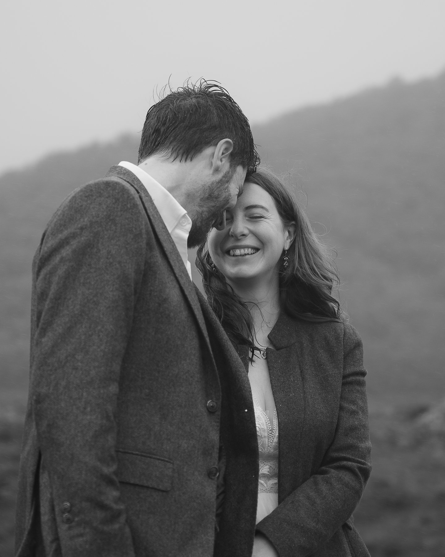 Couple smiling closely together outdoors, sharing an intimate and joyful moment.
